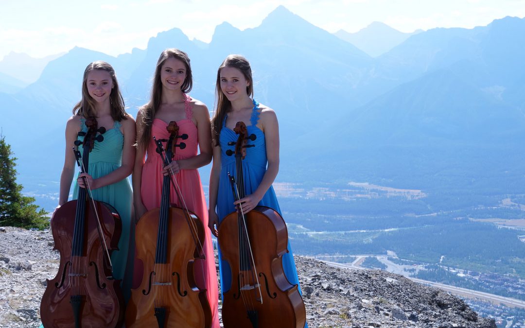 Luka, Ine and Mari Coetzee are the Three Sisters cello trio, pictured in front of the Three Sisters mountain peaks near Canmore, Alberta.