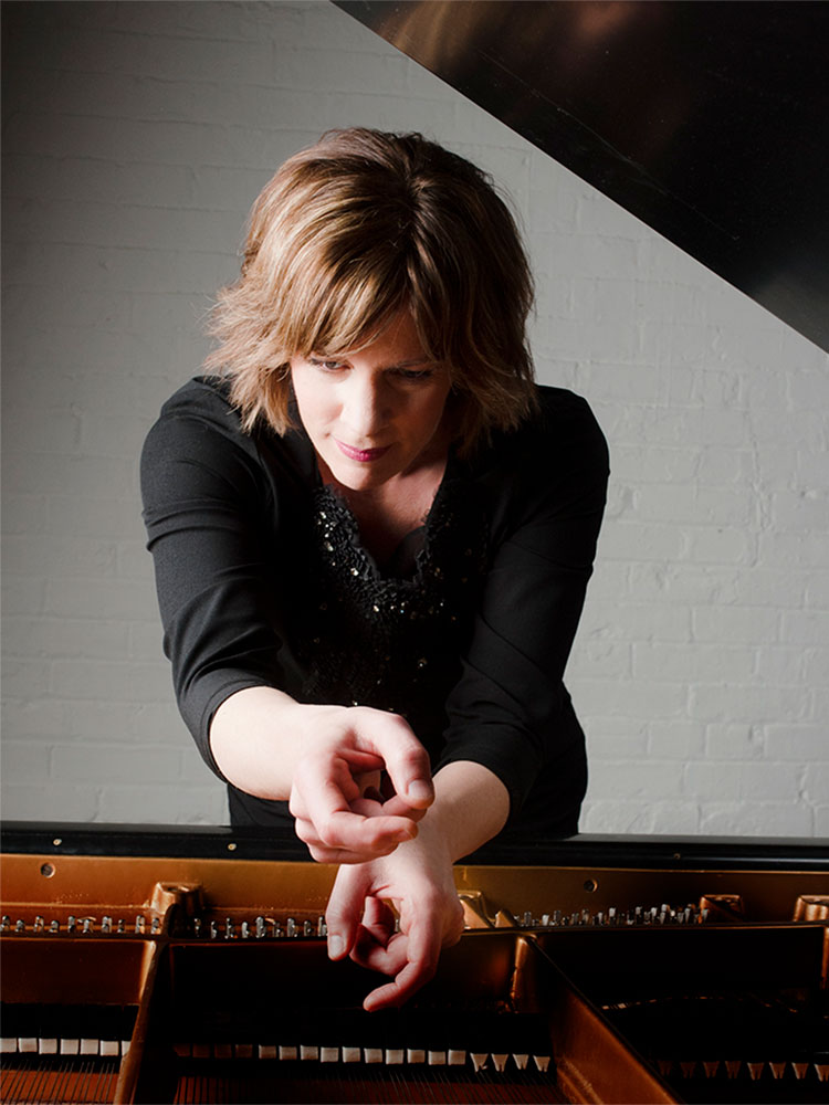 Image of collaborative pianist Susanne Ruberg Gordon leaning on piano.