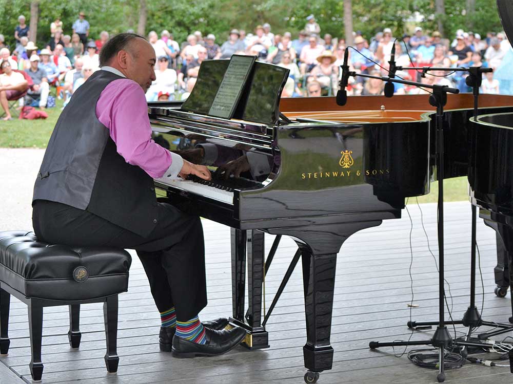 Honens artistic director Jon Kimura-Parker at piano during free family outreach concert September 2022 outdoors audience in background